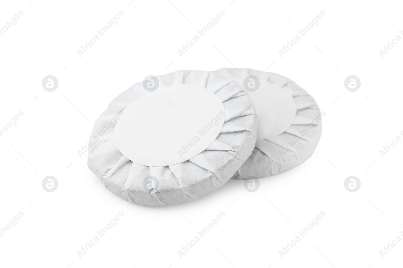 Photo of Disc shaped traditional Chinese pu-erh tea in paper wrap isolated on white