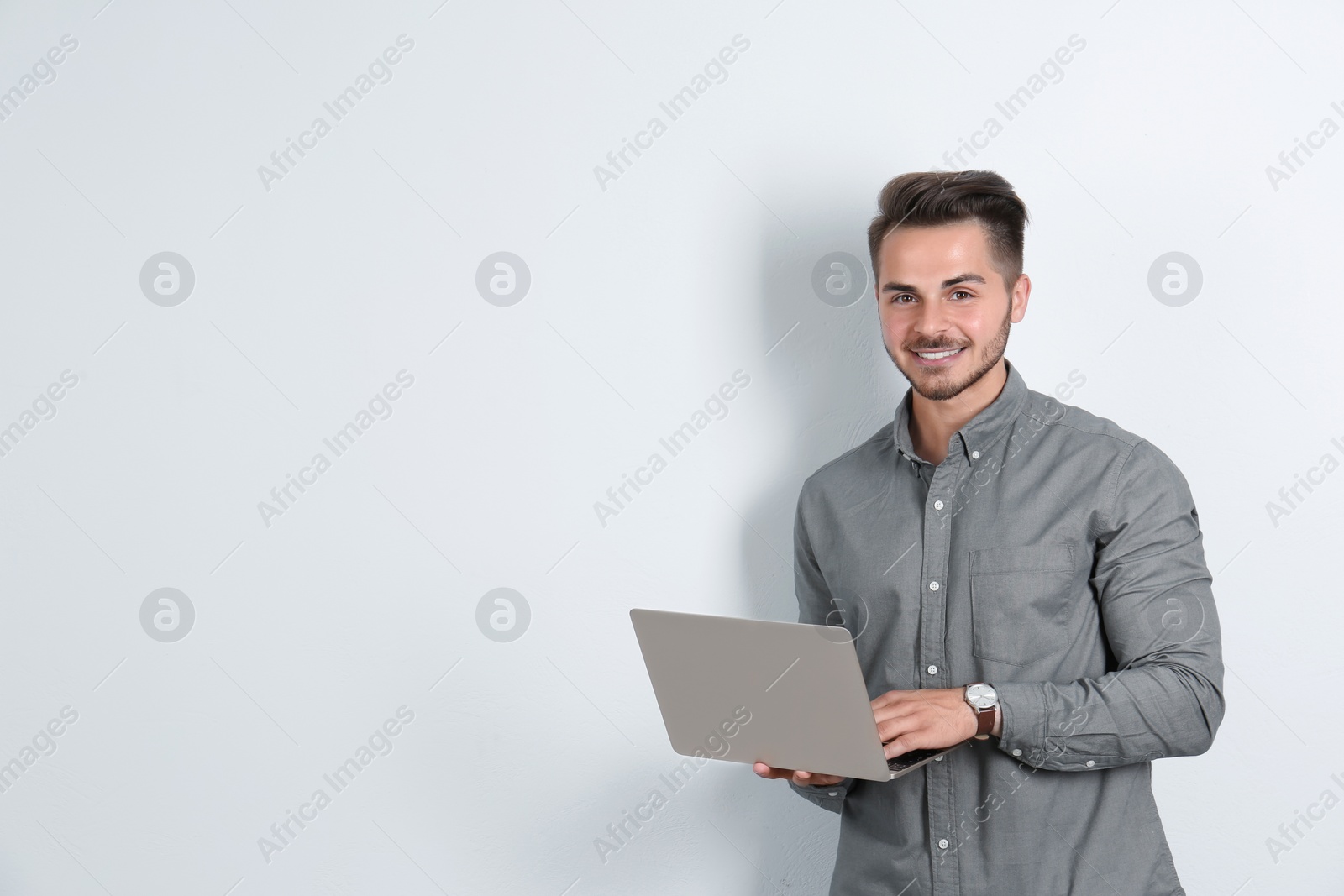 Photo of Man in casual clothes with laptop on light background