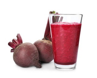 Glass of beet juice and fresh vegetable on white background