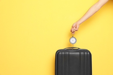 Photo of Woman weighing suitcase against color background, closeup. Space for text