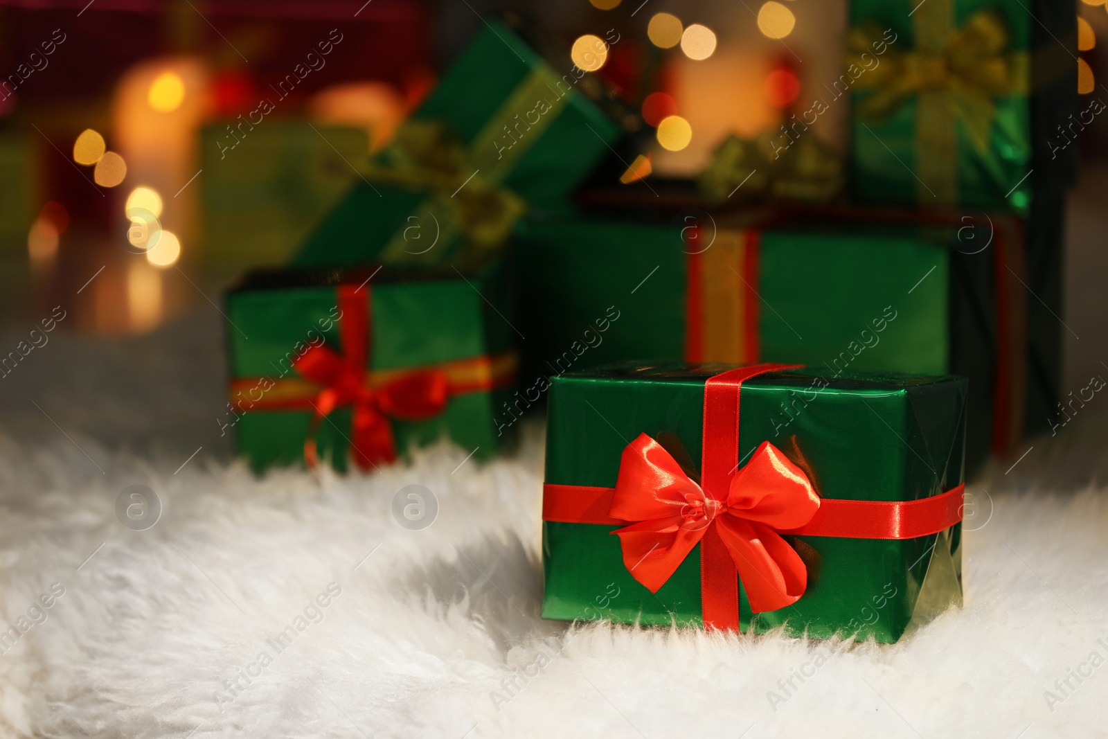 Photo of Beautiful Christmas gifts on furry carpet in room, space for text