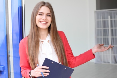 Beautiful real estate agent with clipboard outdoors