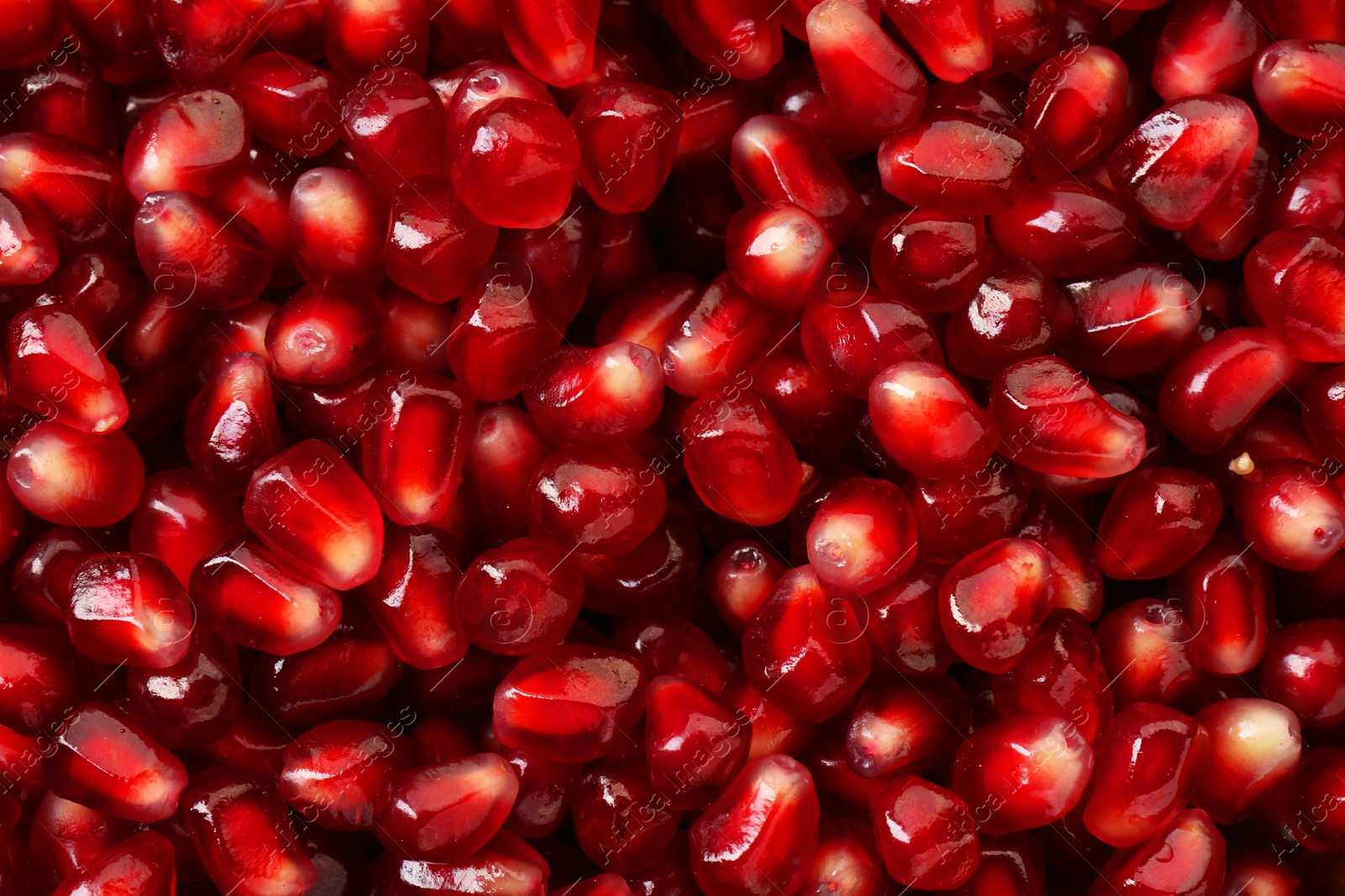 Photo of Ripe juicy pomegranate grains as background, top view