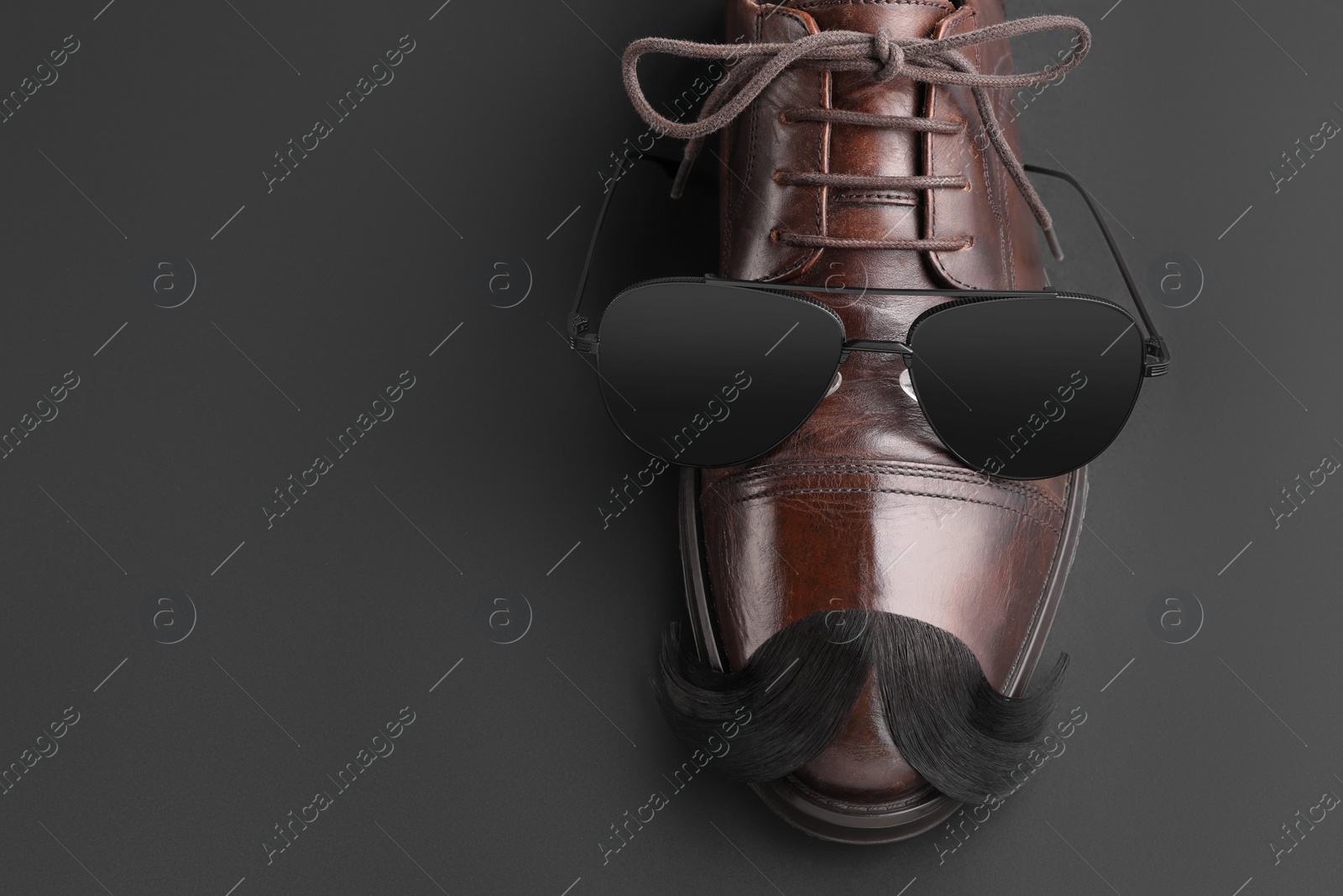 Photo of Artificial moustache, shoe and sunglasses on black background, top view. Space for text