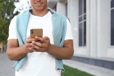 Man using modern mobile phone outdoors, closeup