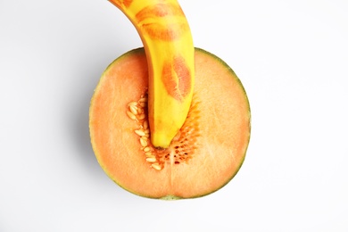 Photo of Fresh melon and banana with red lipstick marks on white background, top view. Sex concept