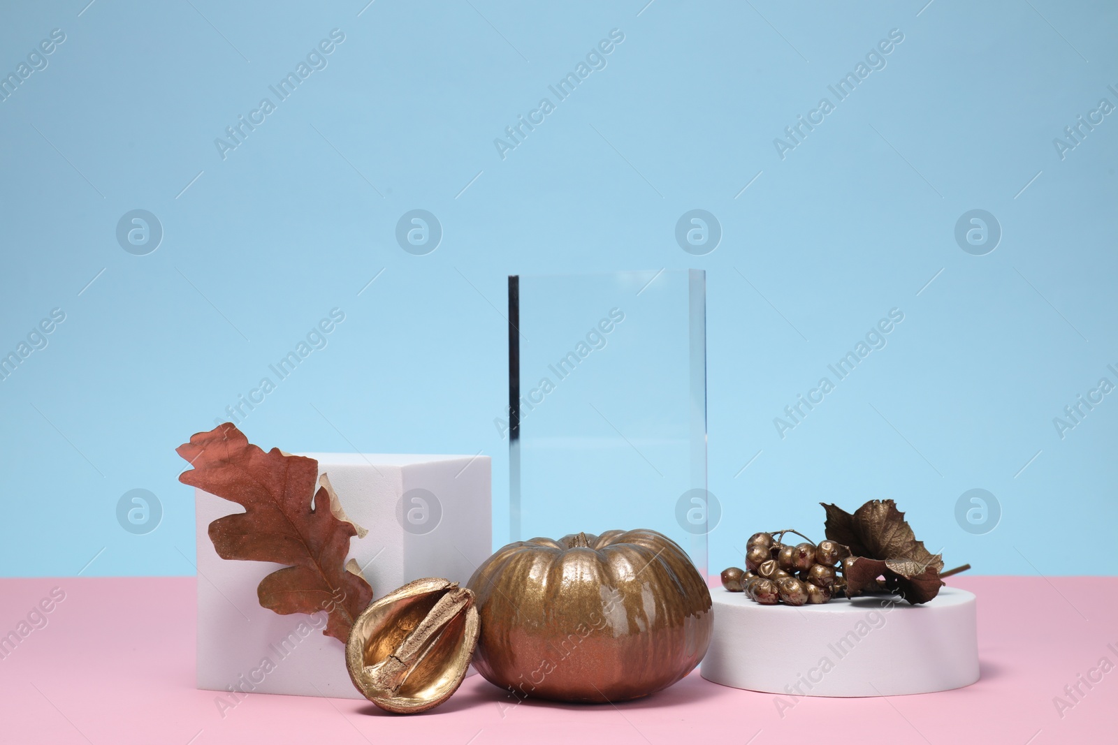 Photo of Stylish presentation for product. Geometric figures, and autumn golden decor on color background