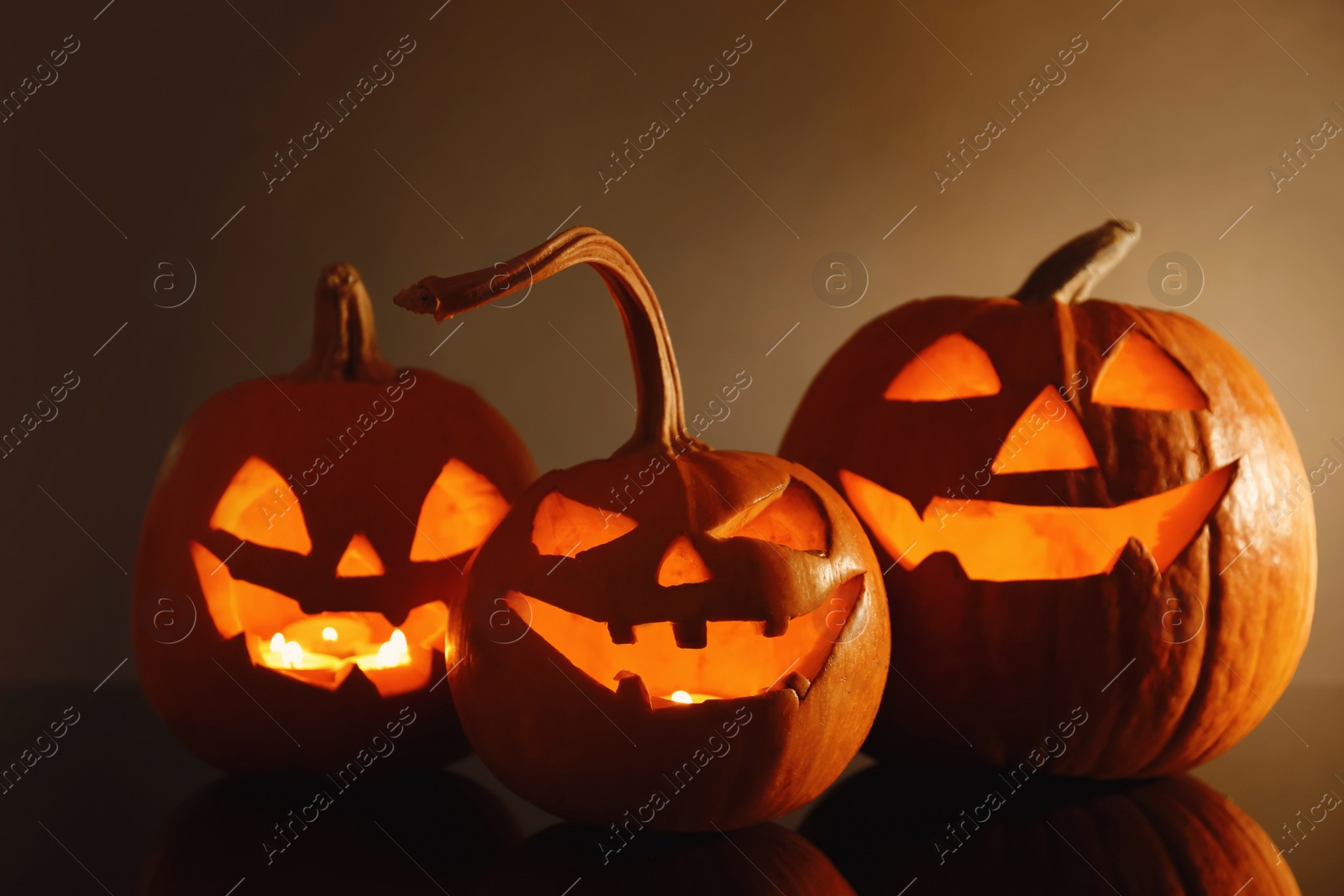 Photo of Halloween pumpkin heads. Glowing jack lanterns on dark background