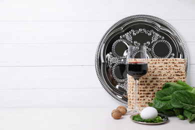 Photo of Symbolic Pesach (Passover Seder) items on white table, space for text
