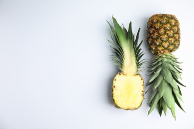 Photo of Whole and cut pineapples on white background, flat lay. Space for text