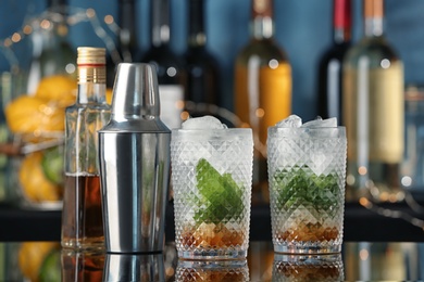 Photo of Delicious mint julep cocktail in glasses on bar counter