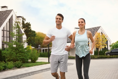 Photo of Sporty couple running on street. Healthy lifestyle