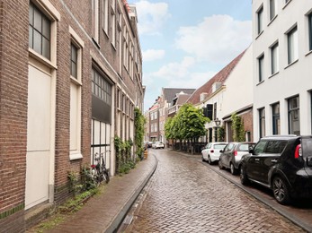 Photo of Picturesque view of city street with beautiful buildings and parked cars