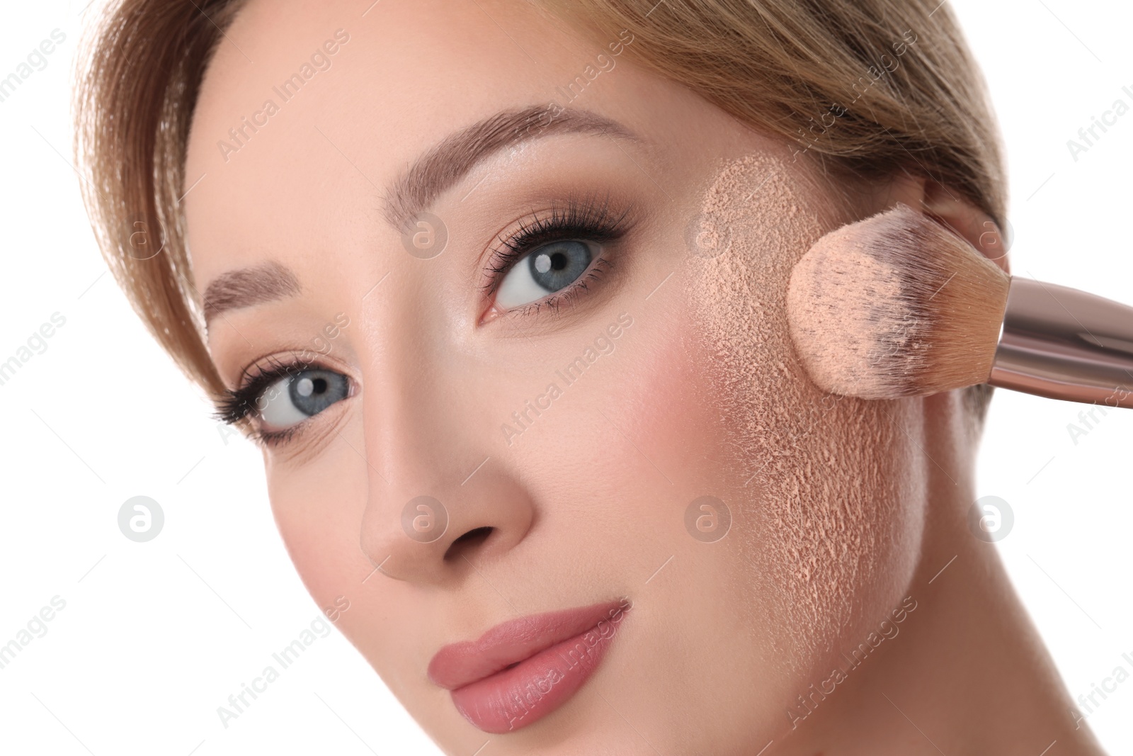 Photo of Beautiful young woman applying face powder with brush on white background, closeup