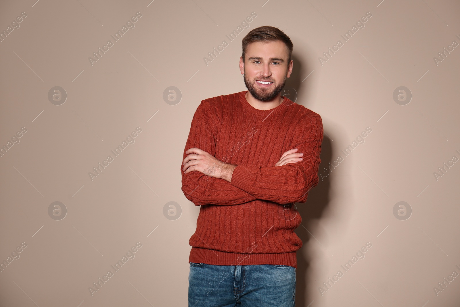 Image of Handsome man wearing warm sweater on beige background 