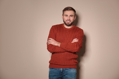 Image of Handsome man wearing warm sweater on beige background 