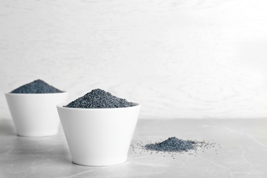 Poppy seeds in bowl on table. Space for text