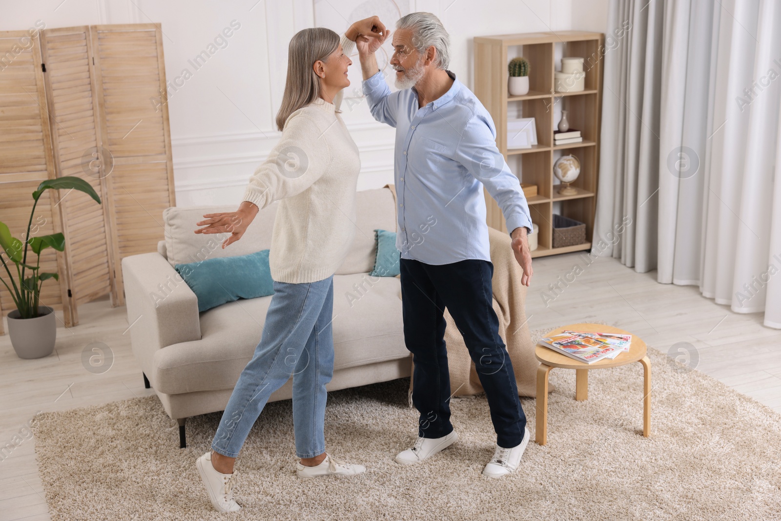 Photo of Happy affectionate senior couple dancing at home