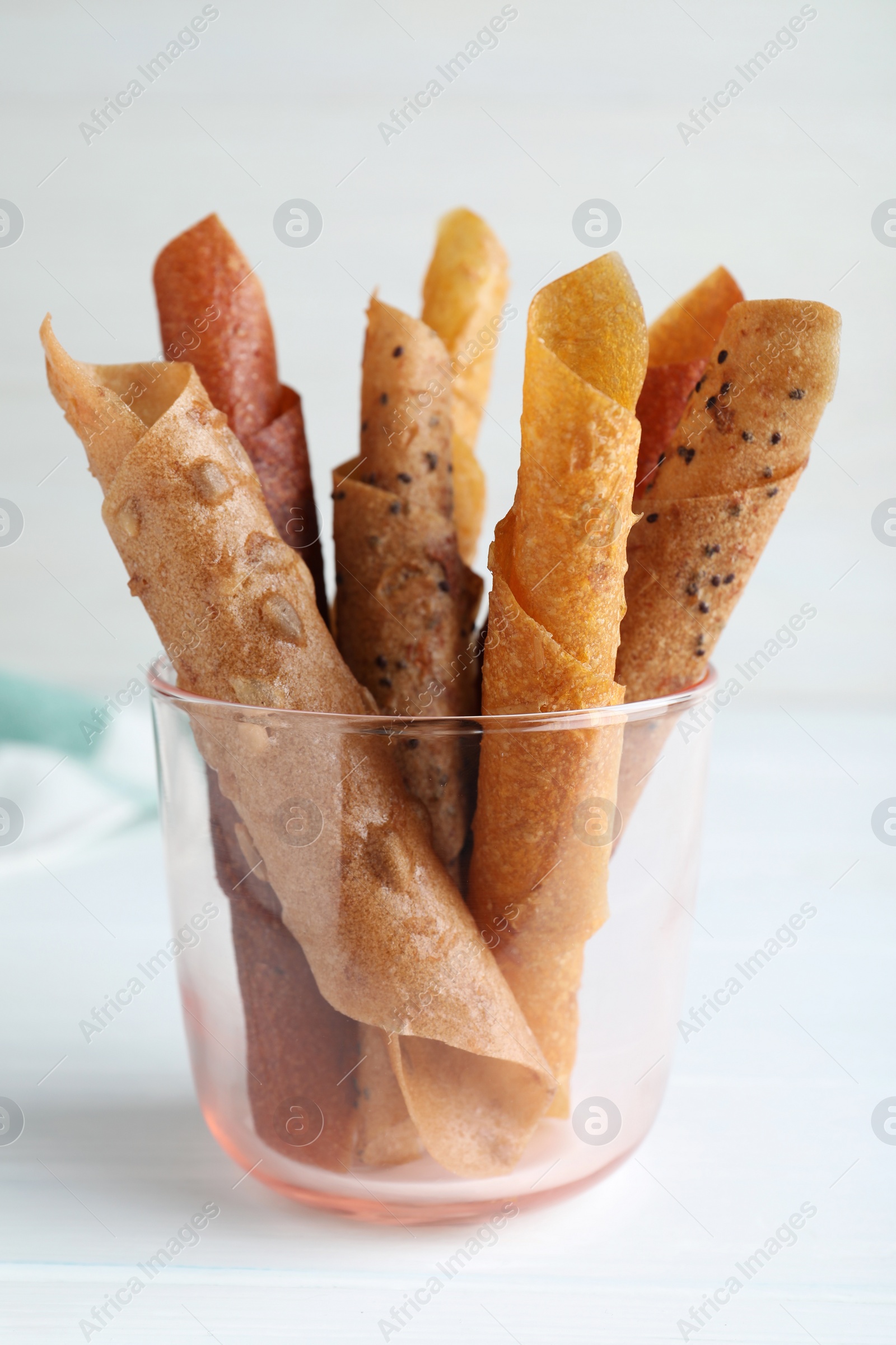 Photo of Delicious fruit leather rolls on white wooden table