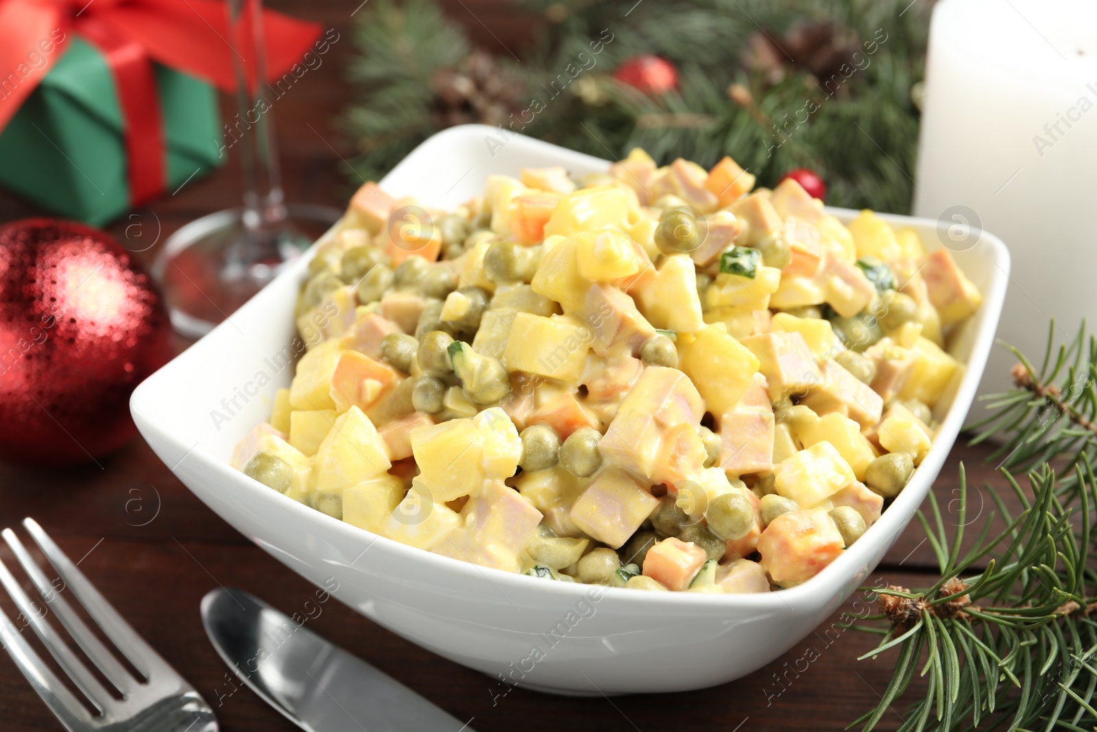 Photo of Fresh Russian salad Olivier in white bowl on table, closeup