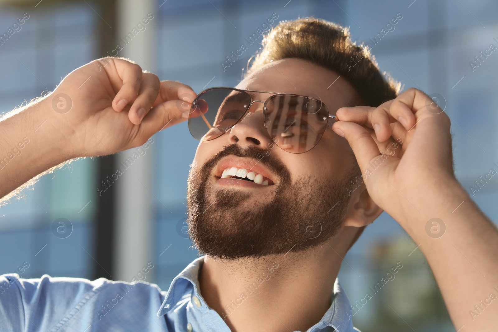 Photo of Handsome smiling man in sunglasses outdoors on sunny day