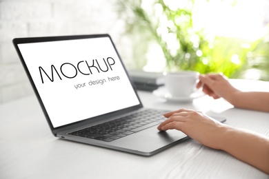 Image of Woman using modern laptop with text Mockup Your Design Here on screen, closeup