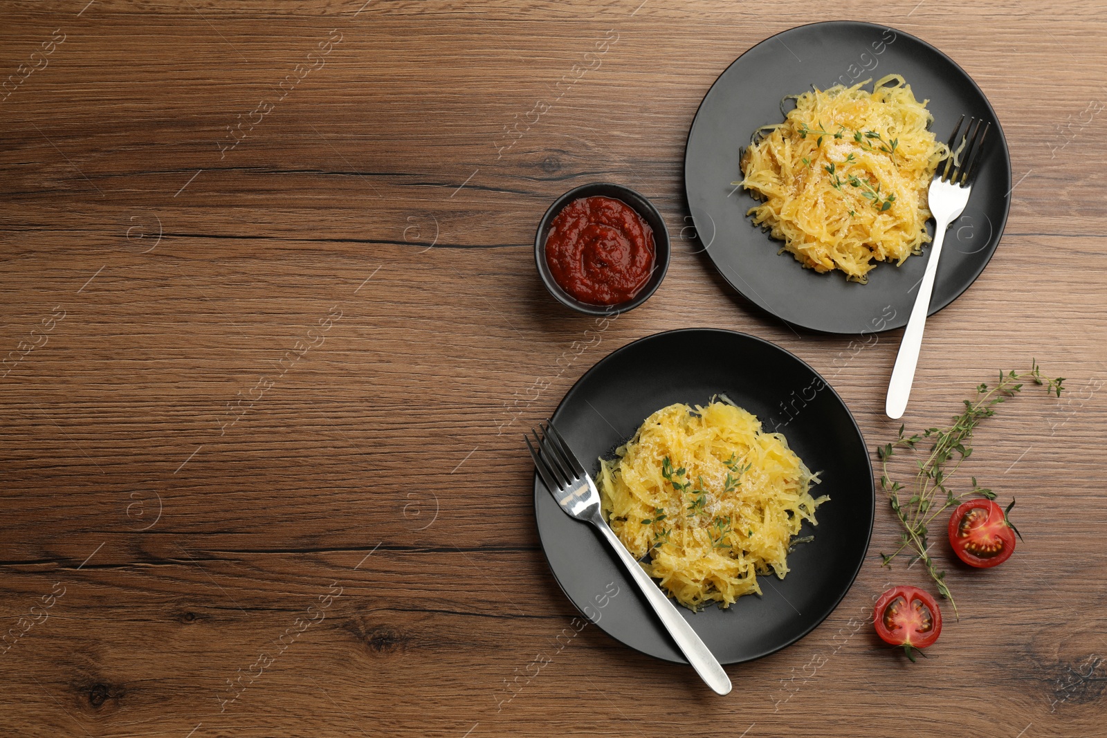 Photo of Tasty spaghetti squash with thyme and cheese served on wooden table, flat lay. Space for text