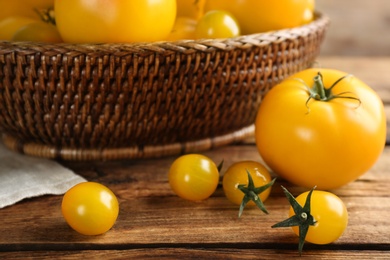 Photo of Ripe yellow tomatoes on wooden table, closeup