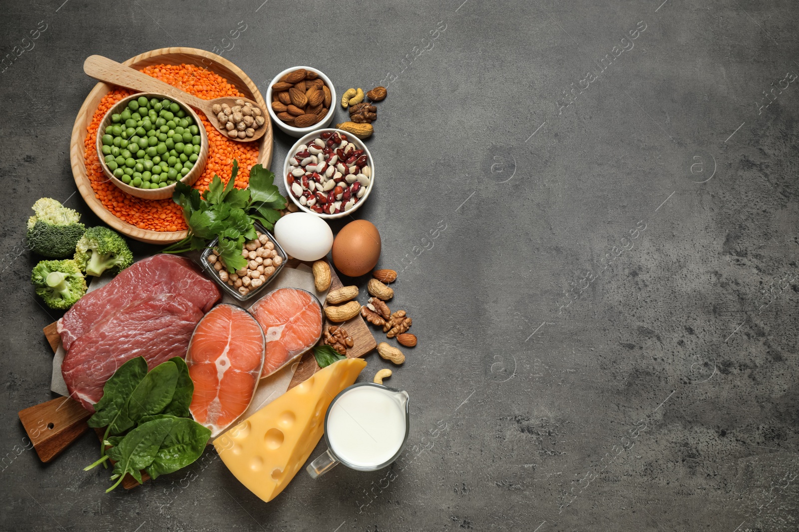 Photo of Products rich in protein on grey table, flat lay. Space for text