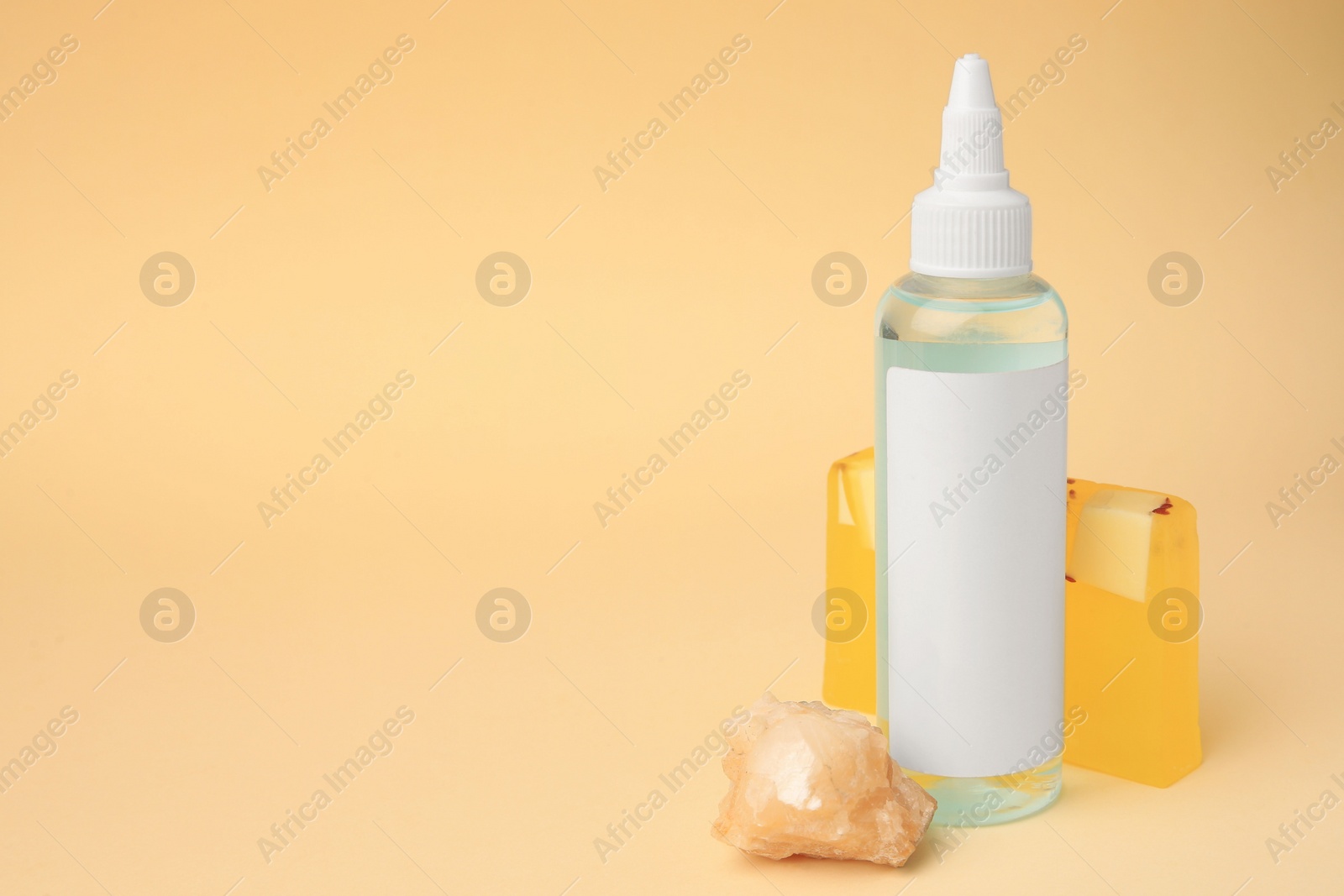 Photo of Cosmetic products and quartz gemstone on beige background. Space for text
