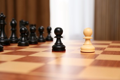 Photo of Black and white pieces among others on chessboard indoors