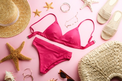 Photo of Beautiful bikini and beach accessories on pink background, flat lay