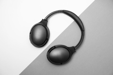 Photo of Modern wireless headphones on color background, top view