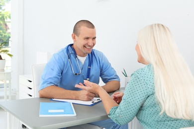 Male medical assistant consulting female patient in clinic