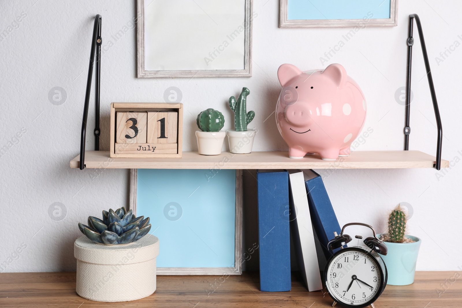 Photo of Color piggy bank on shelf over table in room. Cute interior element