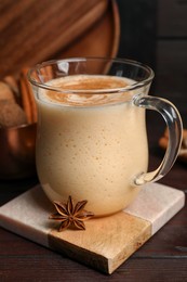 Photo of Delicious eggnog with anise on wooden table