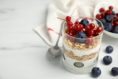 Delicious yogurt parfait with fresh berries on white table, closeup. Space for text