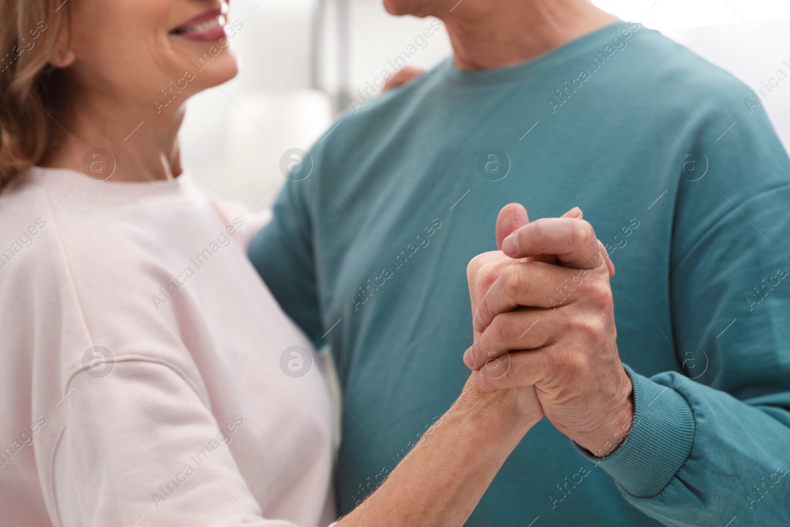 Photo of Happy senior couple dancing together at home, closeup