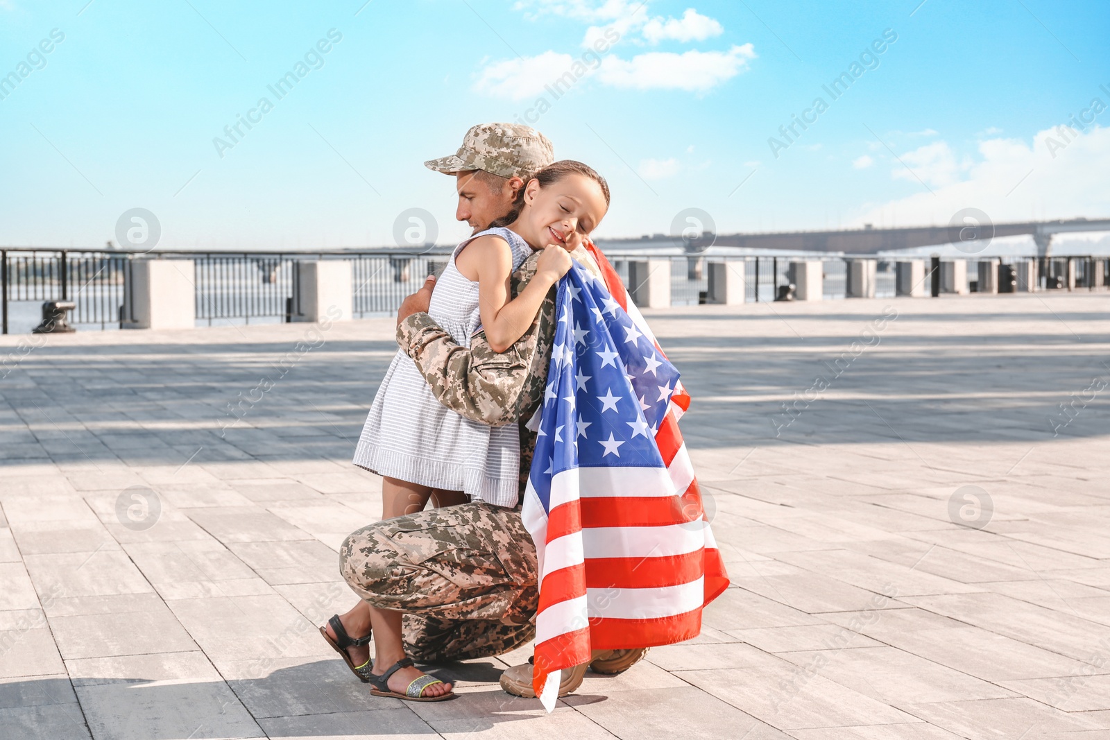 Photo of Soldier with flag of USA and his little daughter hugging outdoors, space for text