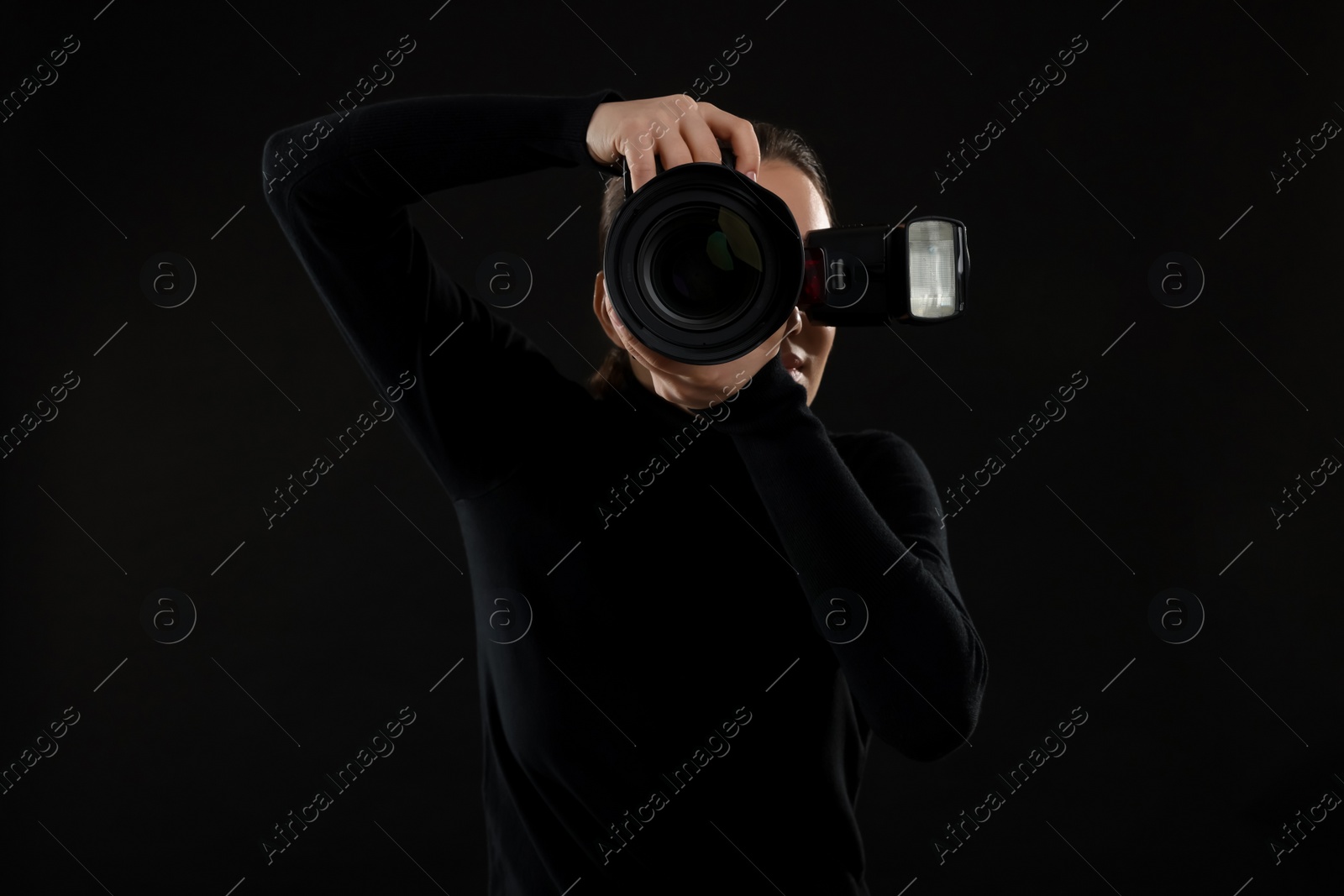 Photo of Professional photographer taking picture on black background