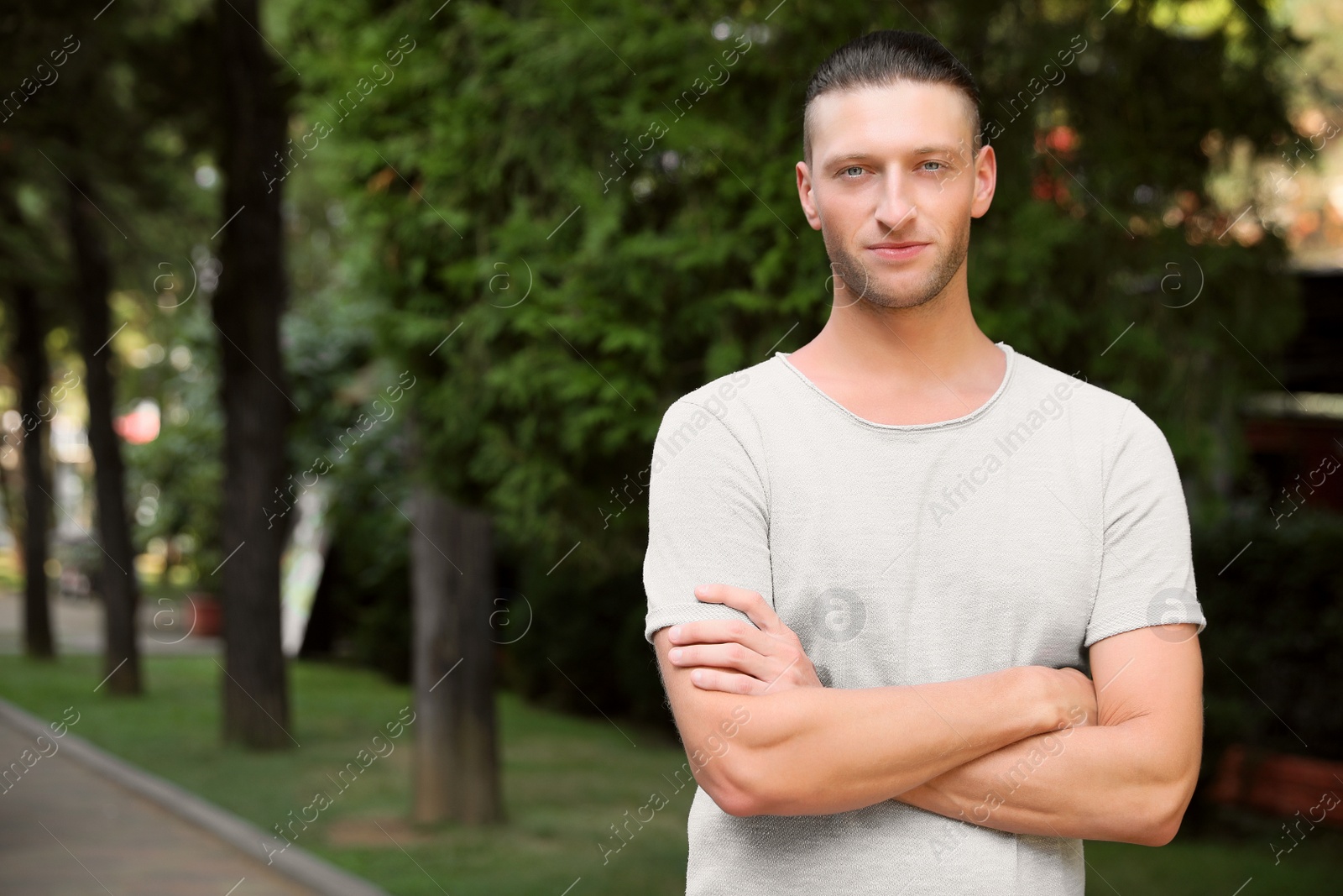 Photo of Portrait of handsome young man in park, space for text