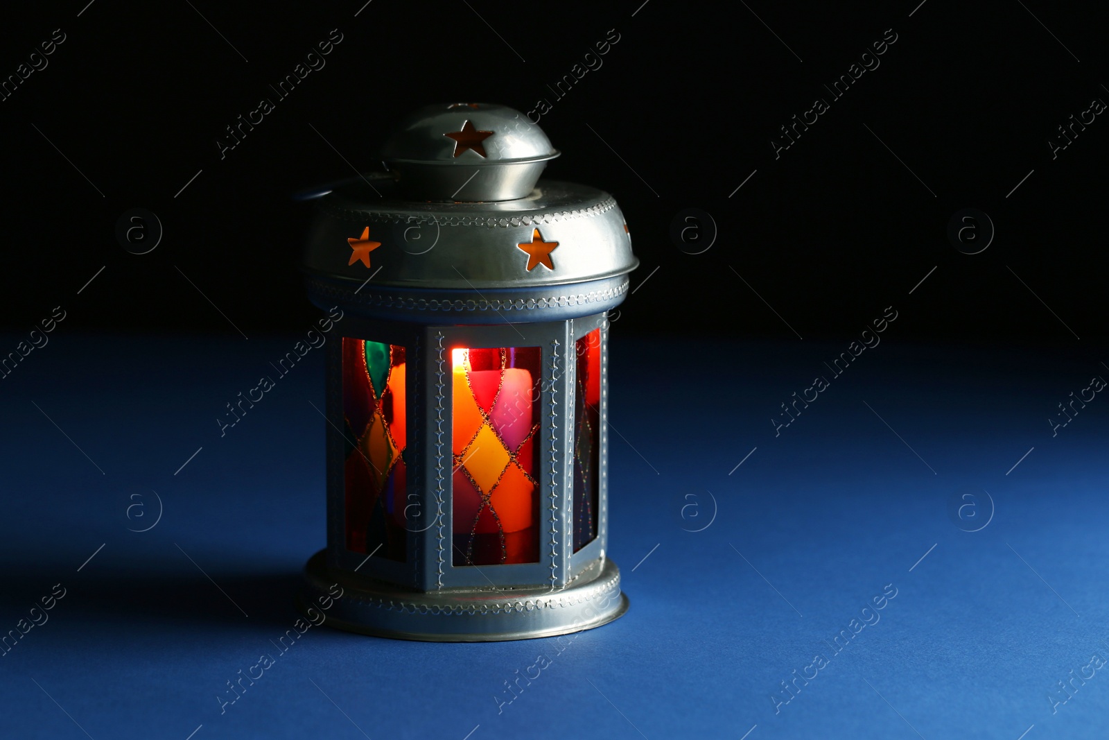 Photo of Decorative Arabic lantern on table against dark background. Space for text