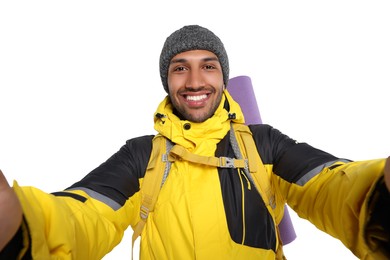Photo of Happy tourist with backpack taking selfie on white background
