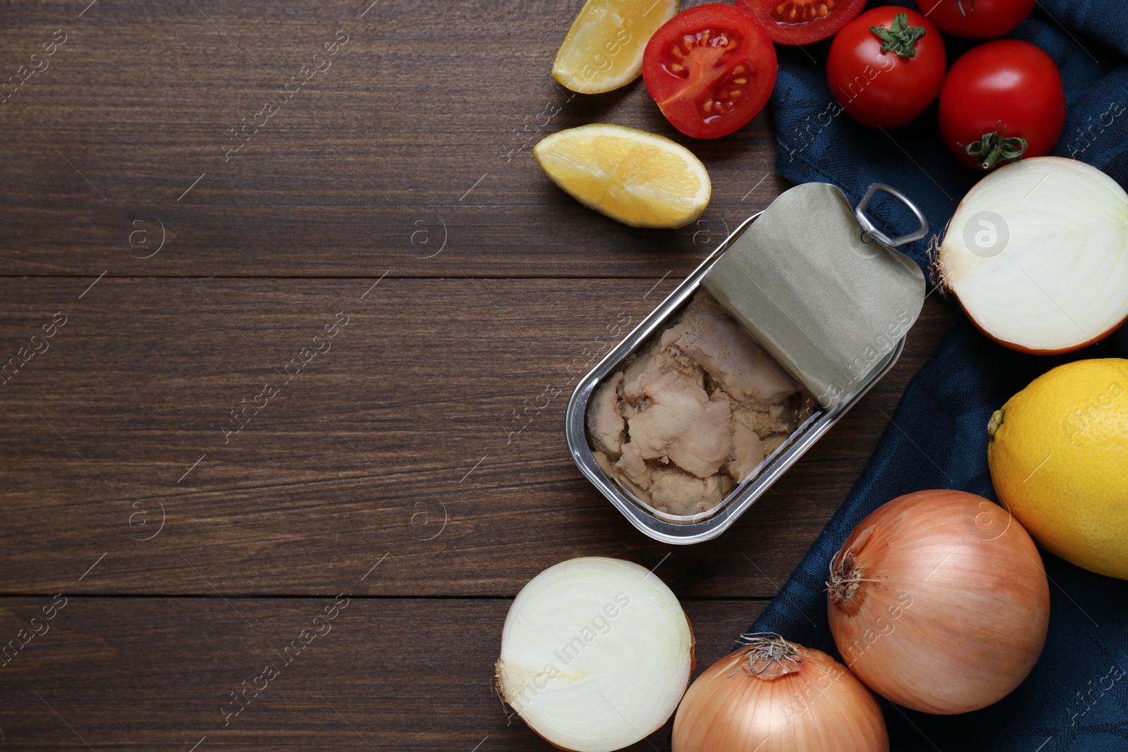 Photo of Flat lay composition with tin can of tasty cod liver and different products on wooden table. Space for text