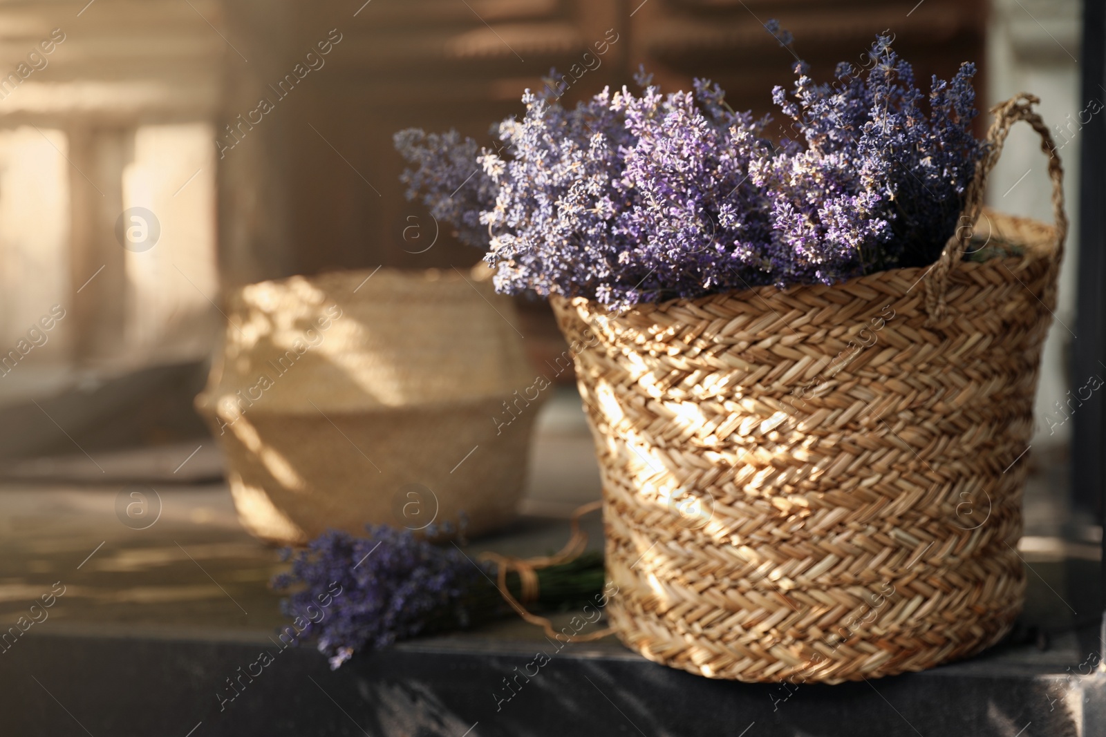 Photo of Wicker basket with beautiful lavender flowers near building