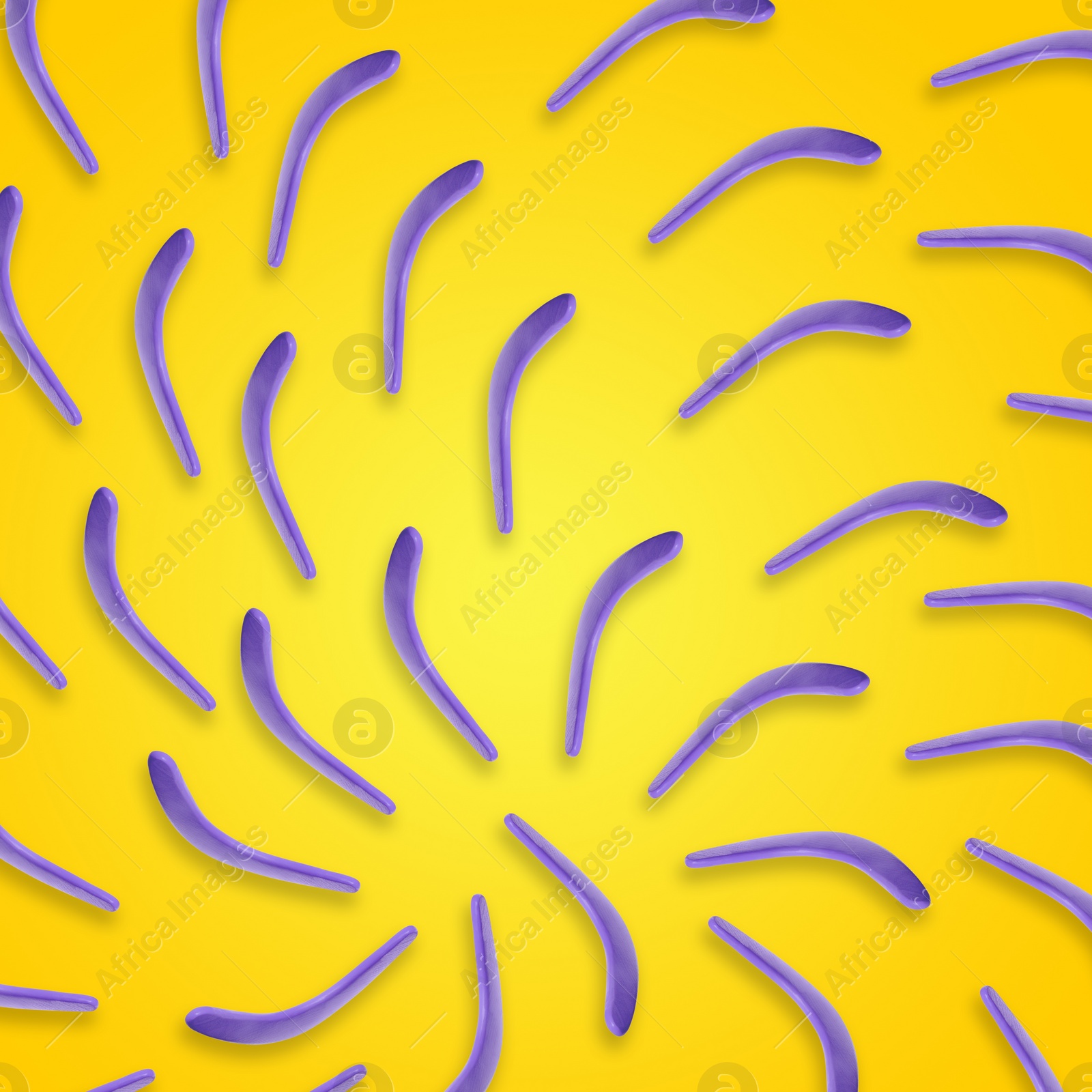 Image of Violet boomerangs on yellow background, flat lay