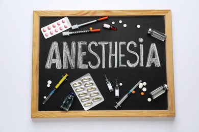 Photo of Blackboard with word Anesthesia and drugs on white background, top view
