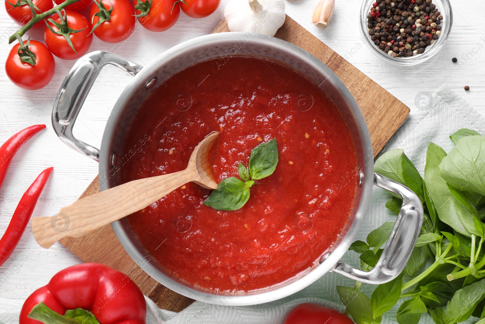 Photo of Delicious tomato sauce on white wooden table, flat lay