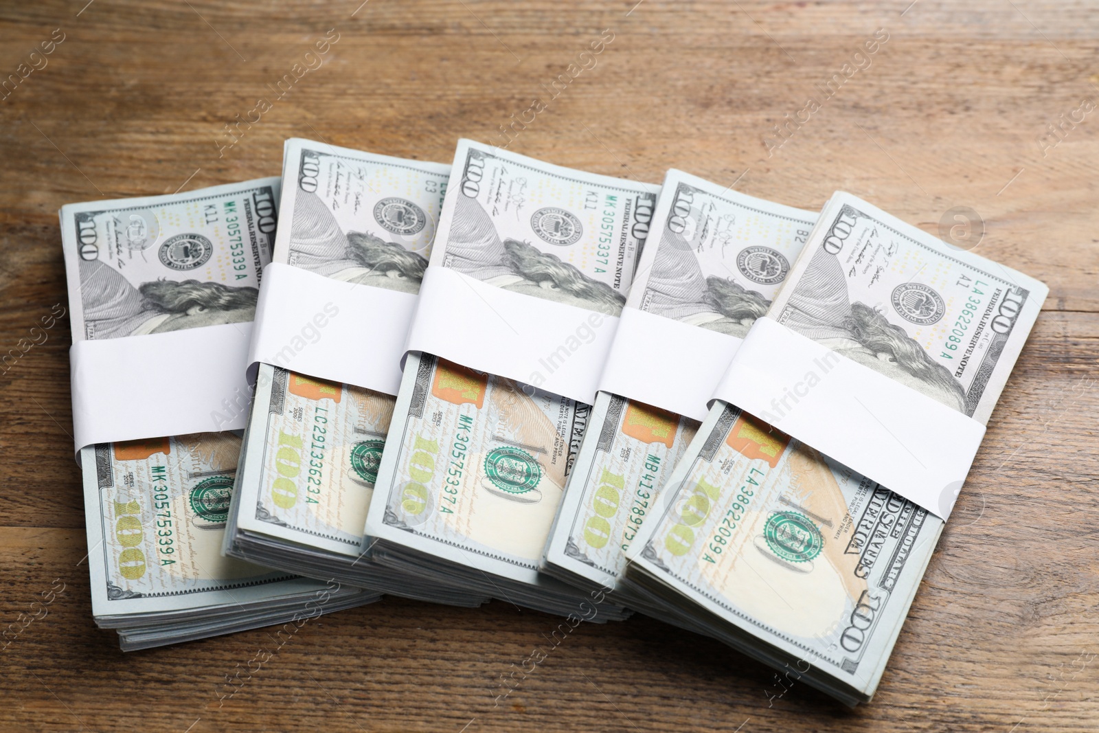 Photo of Many dollar banknotes on wooden table. American national currency