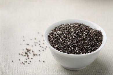 Bowl with chia seeds on table, space for text